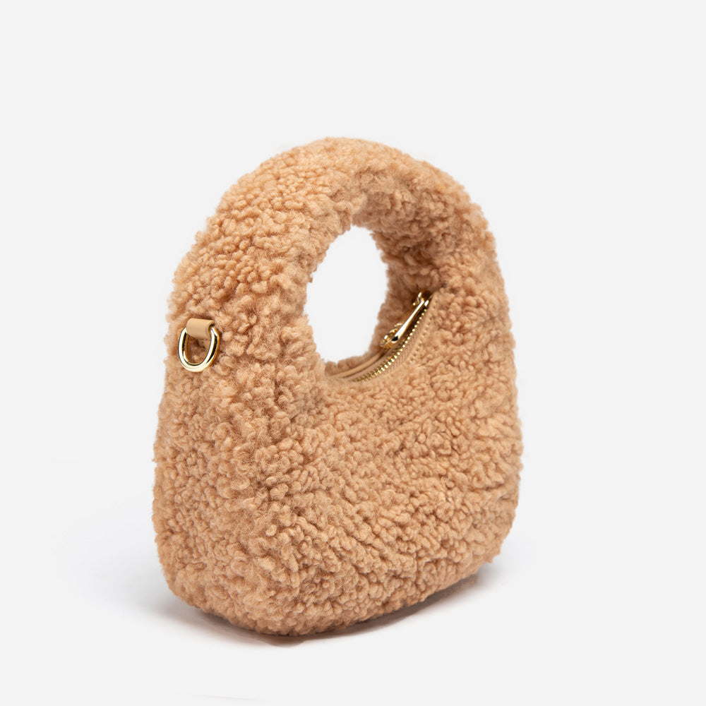Beige shearling handbag with gold zipper on a white background