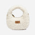 White shearling handbag with UGG logo on a white background