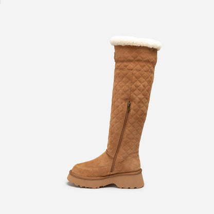 Tan quilted knee-high UGG boot with white fur lining on a light beige background