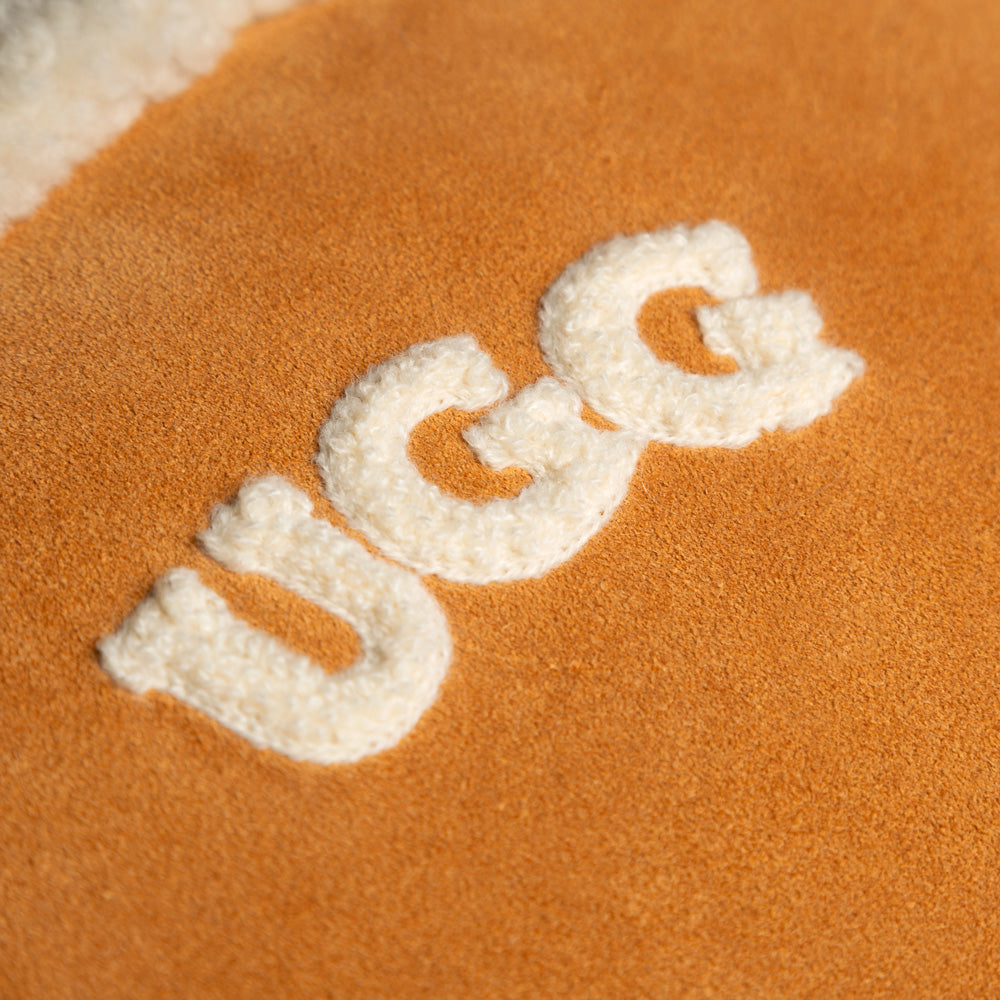Close-up of a UGG logo on orange fabric.