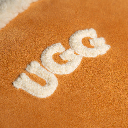 Close-up of a UGG logo on orange fabric.