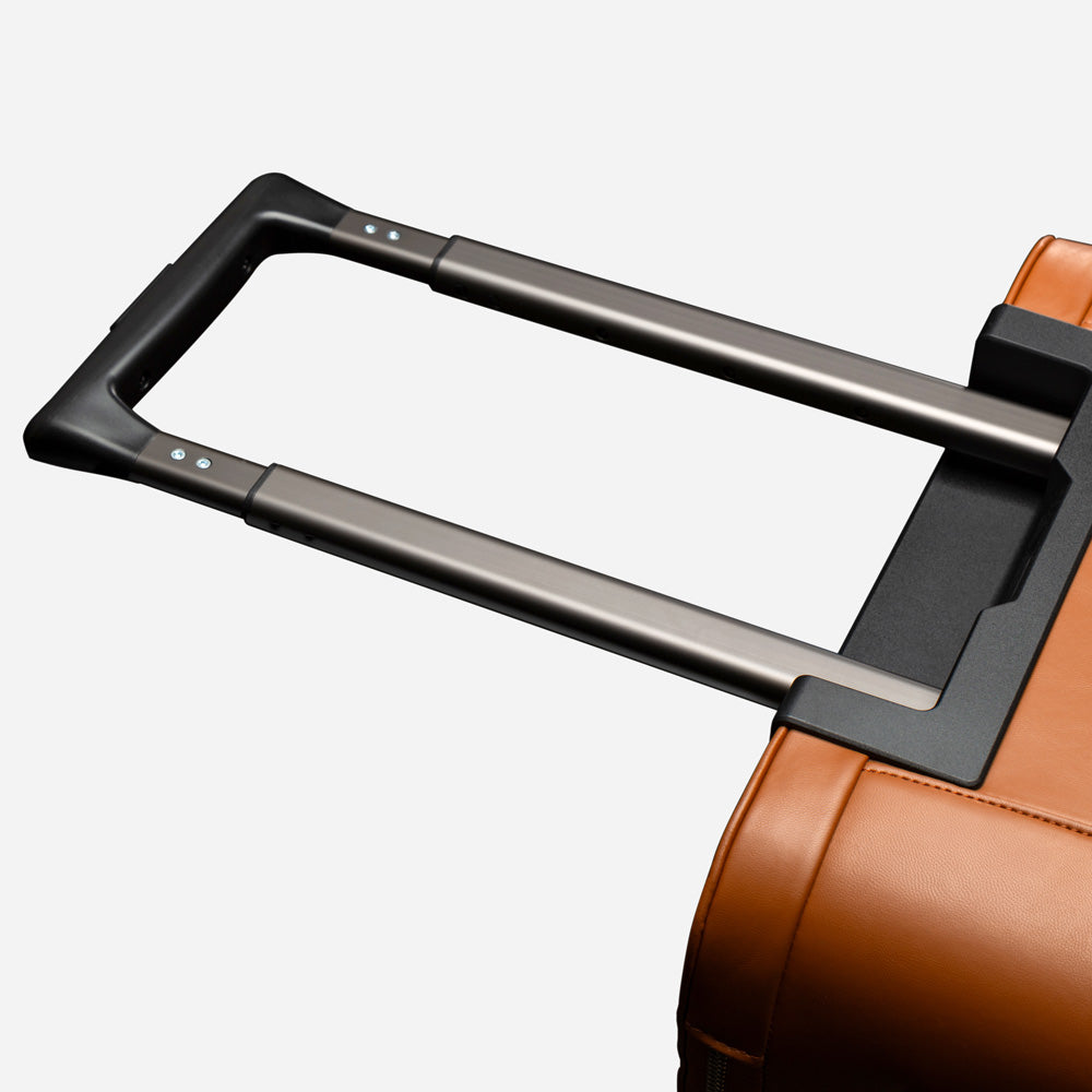 Close-up of a brown suitcase handle on a white background